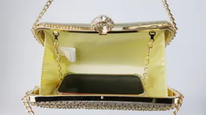 Detailed view of rhinestone evening clutch interior with chain and ring clasp capacity display.