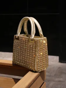 Gold rhinestone evening handbag detail, sparkling crystal tote bag, luxury party purse.