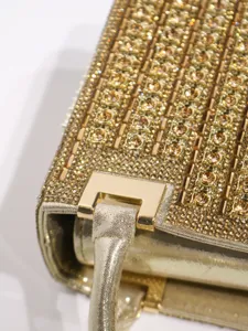 Detailed shot of luxury gold rhinestone evening bag handle and metallic hardware craftsmanship.