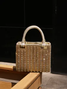 Close-up of luxury gold rhinestone evening handbag, sparkling crystal details and elegant metal hardware.