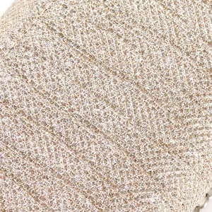 Close-up detail of glittering gold evening bag fabric, luxurious sparkling texture.