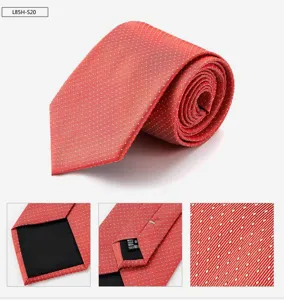 Red silk tie with white polka dot pattern, detailed view of fabric texture and care label.