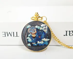 Close-up detail of the vintage gold Chinese zodiac tiger pocket watch with chain and quartz movement.