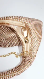 Nahaufnahme eines funkelnden Strass-Abendtaschen-Details mit goldenem Reißverschluss und Kette.