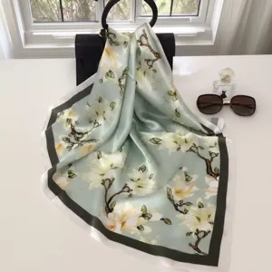 Close-up of elegant silk square scarf with floral print, delicate texture and draping.