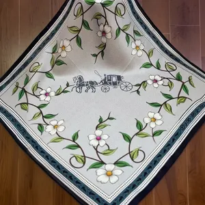 Detail shot of a mulberry silk square scarf with horse carriage and floral vine print design.