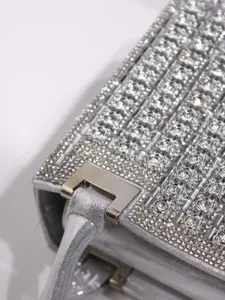 Detailed shot of a sparkling rhinestone evening handbag in silver, elegant party clutch purse.