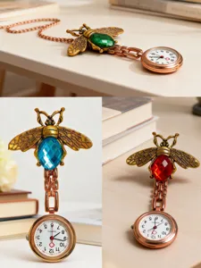 Close-up detail of vintage bronze bee nurse watch with crystal gemstone abdomen and chain.