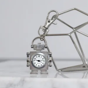 Detailed close-up of a silver robot-shaped quartz pocket watch keychain, unique accessory.