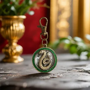Detailed shot of vintage bronze pocket watch keychain with green glitter bezel and coiled snake.