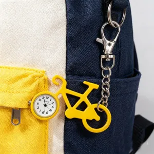 Close-up detail van een creatief geel fietsvormig zakhorloge met een stevige metalen ketting.