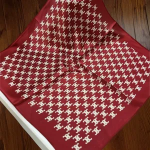 Close-up detail of the red silk square scarf featuring classic monogram pattern design.