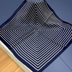 Close-up detail shot of navy blue and white geometric striped silk square scarf pattern.