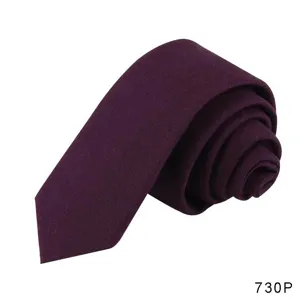 Close-up detail shot of a rolled dark purple solid casual necktie, showing soft texture.