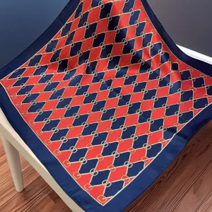Silk scarf detail showcasing the exquisite red and blue chain pattern and smooth fabric texture.