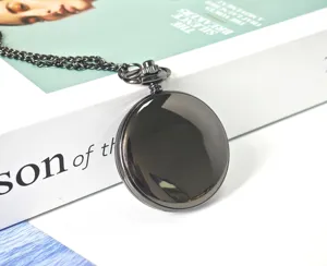 Orologio da tasca nero classico in metallo nel dettaglio con catena su sfondo rivista.