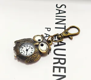 Detailed view of bronze owl pocket watch keychain, vintage quartz timepiece charm and accessory.