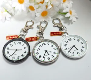 Detailopname van het studenten examen zakhorloge met duidelijke wijzerplaat en rode bedel.