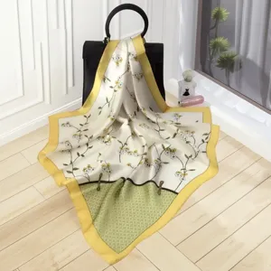 Exquisite silk square scarf with floral print and yellow border, soft texture, elegant detail.