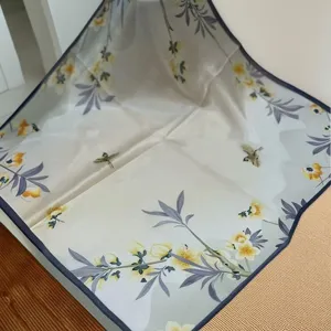 Detailed view of 55x55cm mulberry silk square scarf with elegant yellow floral and bird print.