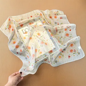 Floral silk scarf detail shot, showcasing the lightweight chiffon texture and delicate print.