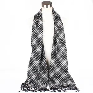 Detailed view of the classic black and white plaid scarf featuring stylish fringe edges.