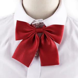 Detailed close-up view of a vibrant red satin JK uniform bow tie on a white shirt.