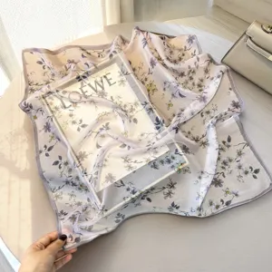 Detailed close-up of a delicate floral print silk square scarf in soft lavender shade.
