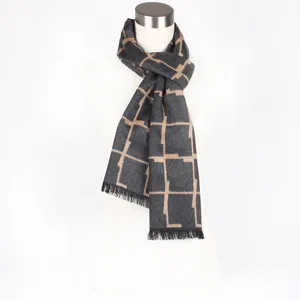 Detailed view of dark grey winter scarf featuring a chic beige geometric grid pattern and fringe.