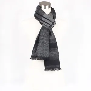 Detailed view of the black and grey striped winter scarf texture and tassel fringe edge.