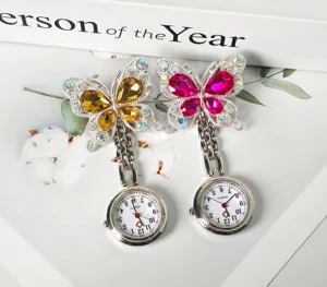 Close-up of sparkling crystal butterfly nurse pocket watch with detailed dial and rhinestones.