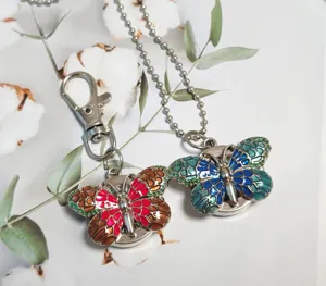 Closeup of colorful gradient butterfly snap watch pocket watch and keychain pendant details.