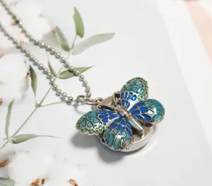 Detailed close-up of a gradient blue green butterfly pocket watch pendant with ball chain.