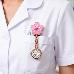 Detailed close-up shot of a pink cherry blossom nurse pocket watch pinned on white uniform.