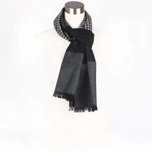 Black and grey houndstooth pattern winter scarf detail featuring classic fringe hem.