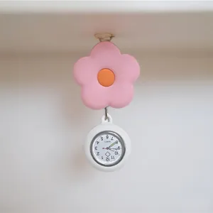 Close-up detail view of the cute pink flower retractable nurse watch with quartz dial.