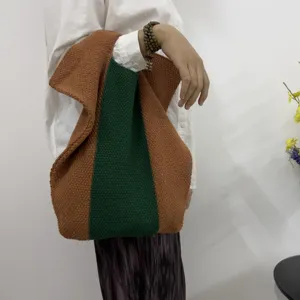 Detailansicht der gestrickten Farbblock-Tasche mit einzigartiger gruner und brauner Textur.