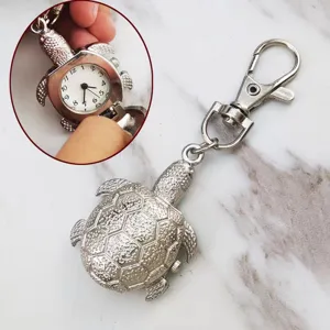 Close-up detail view of the silver turtle pocket watch showing white dial with clear numbers.