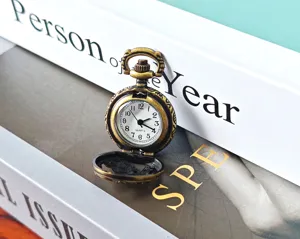 Vintage bronze pocket watch detail display, antique hollow carved quartz timepiece design.