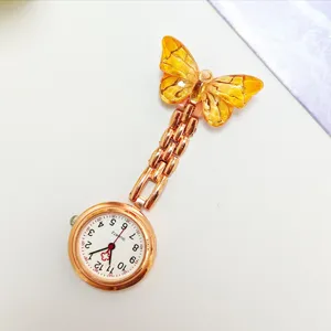 Detail view of the elegant rose gold nurse pocket watch with amber crystal butterfly.