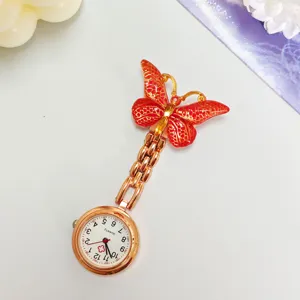 Detail view of the red crystal butterfly nurse pocket watch with quartz dial and brooch pin.