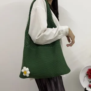 Detailansicht der gruenen Stricktasche mit Bluemchen-Detail im laessigen Alltagsstil.