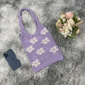 Purple crochet tote bag with cute cream floral pattern, aesthetic knit shoulder bag detail.
