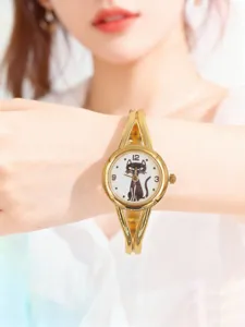 Montre à quartz élégante avec cadran chat noir et bracelet jonc doré pour femmes.