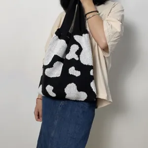 Sac cabas d'épaule en tricot motif vache noir et blanc, vue de détail décontractée.