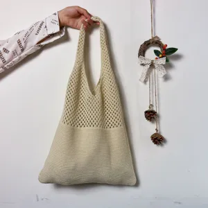 Beige Strick-Tragetasche Detail, mit feinem Netz-Oberteil und festem Boden fuer den Alltag.
