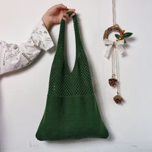 Dunkelgrüne Häkel-Tasche im Detail mit weicher Netzstrick-Textur und geräumigem Design.