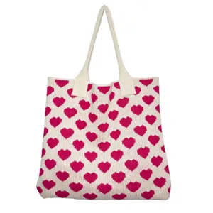Nahaufnahme der rosa Herzmuster Strick Tote Tasche mit weicher gewebter Stoffstruktur.