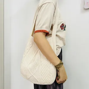 Beige Strick Schultertasche Detail, lässige Zopfmuster Textur, modische Alltagstasche.