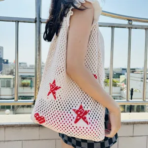 Detailansicht der gestrickten Netztasche mit rotem Sternenmuster für den täglichen Look.